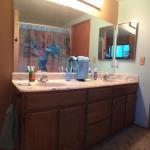 Master bath lavatory has dual sinks and is straight out of the late 80's - oak facing and faux marble.