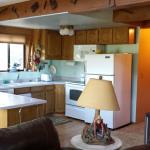 Kitchen is open, moderate size, 80's oak faced cabinets, melamine counters, oak laminate  floor and breakfast bar.